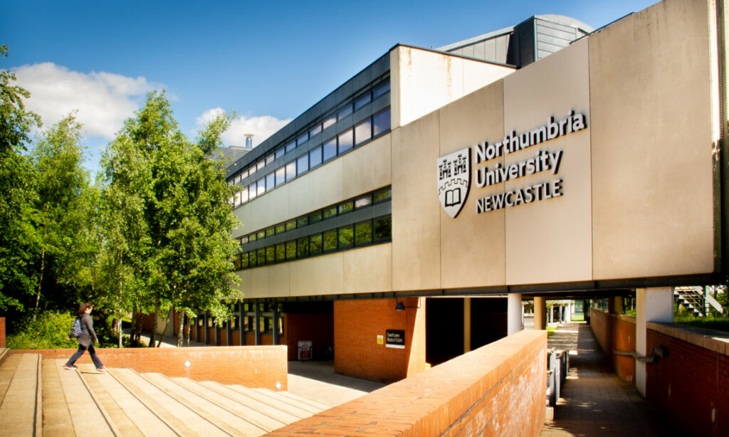 Northumbria University sandstone building, displaying University logo on wall