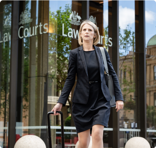 DNA Expert witness Helen Roebuck walking out of Sydney Law Courts, with a wheeled brief case